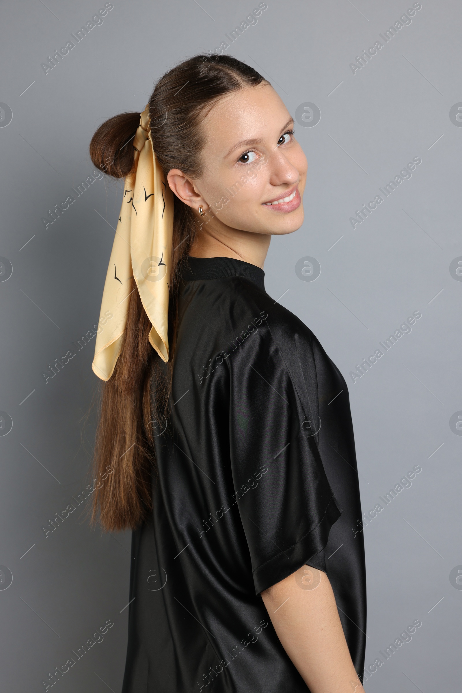 Photo of Teenage girl with stylish bandana on light grey background