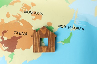 Photo of Wooden house model on world map, top view. Accommodation search