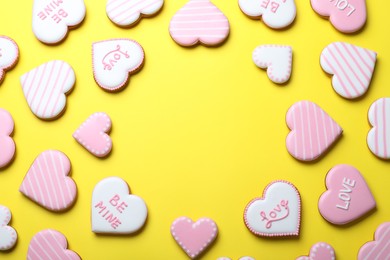 Photo of Frame made of cookies on yellow background, flat lay with space for text. Valentine's day treat