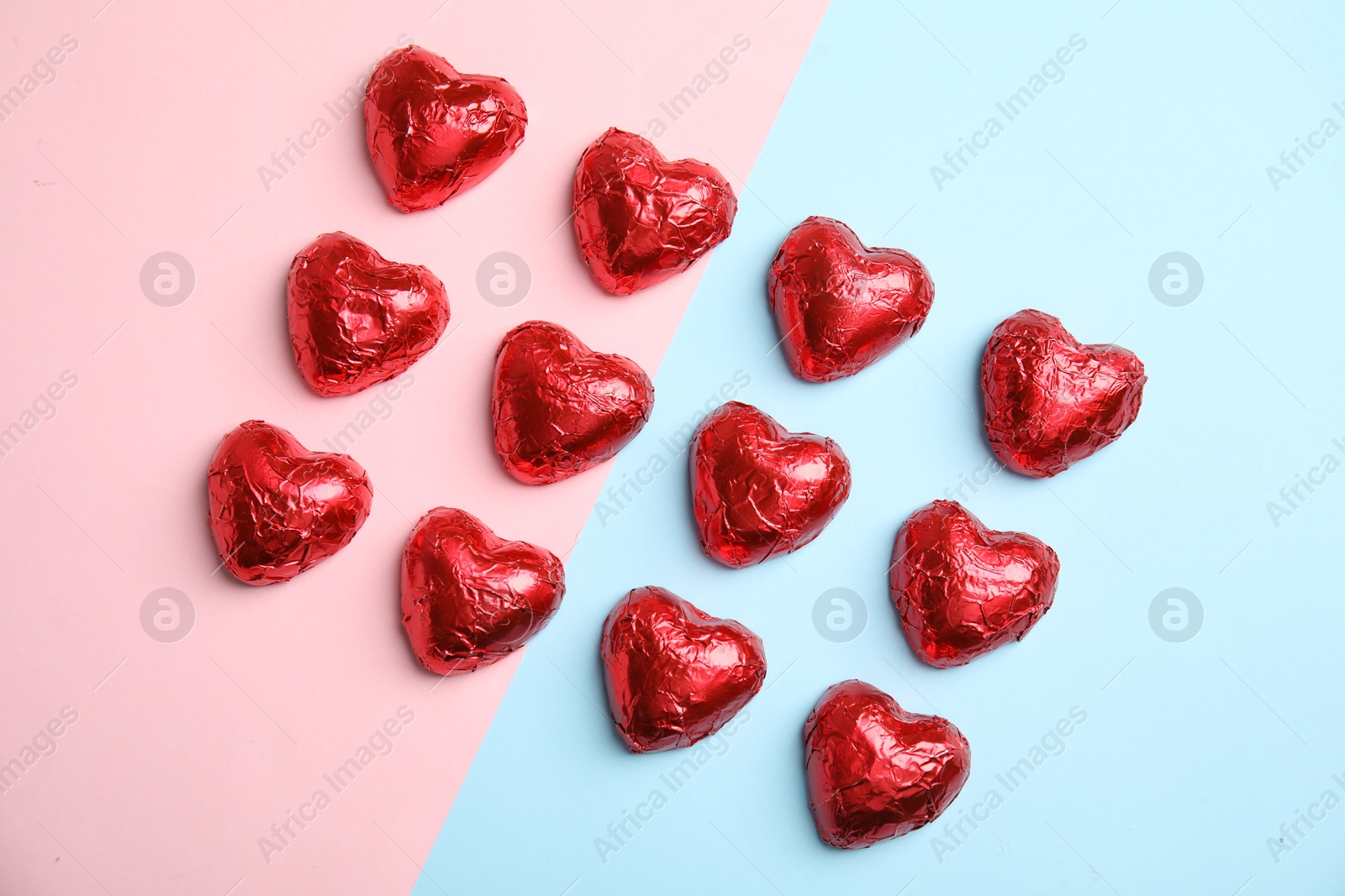 Photo of Heart shaped chocolate candies on color background, flat lay. Valentine's day treat