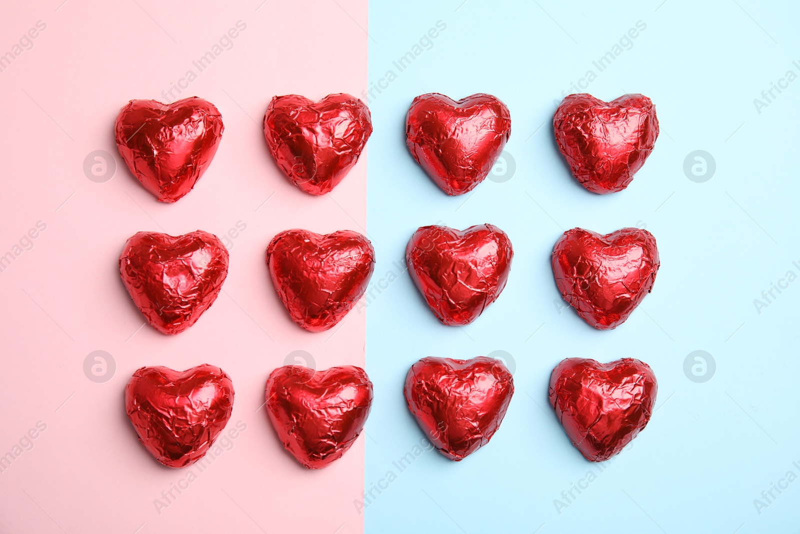 Photo of Heart shaped chocolate candies on color background, flat lay. Valentine's day treat