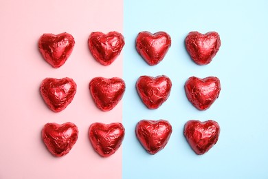 Photo of Heart shaped chocolate candies on color background, flat lay. Valentine's day treat