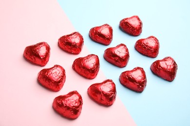 Photo of Heart shaped chocolate candies on color background. Valentine's day treat