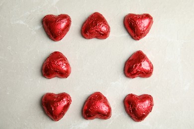 Photo of Heart shaped chocolate candies on light grey table, flat lay. Valentine's day treat