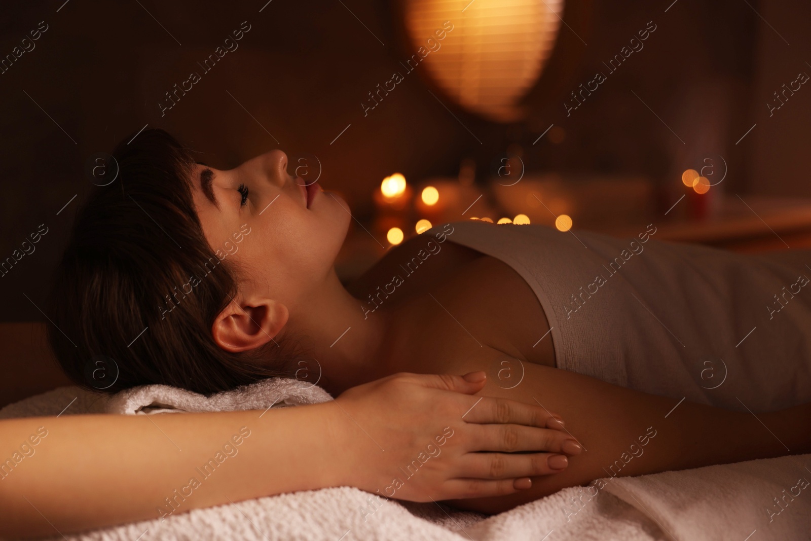 Photo of Young woman receiving massage in spa salon