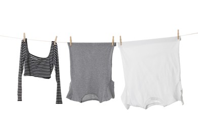 Different clothes drying on laundry line against white background