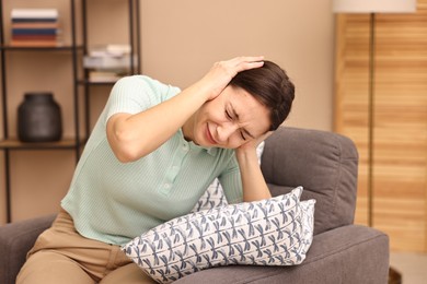 Photo of Annoyed woman covering her ears due to sound at home