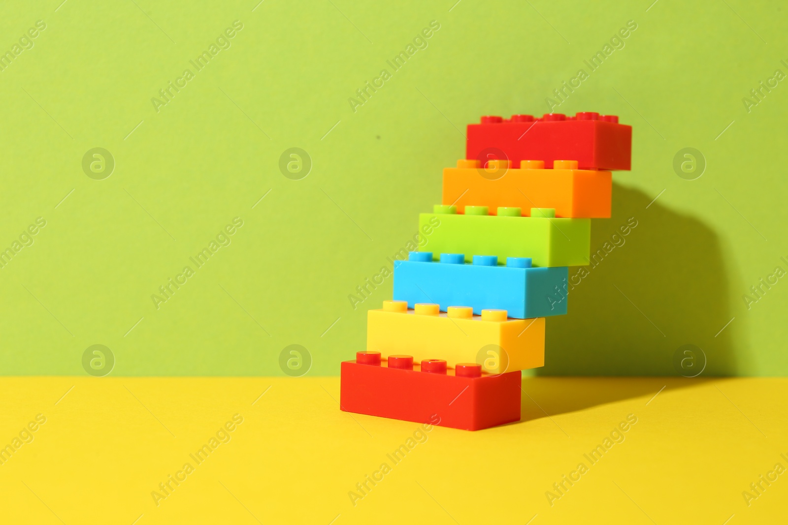 Photo of Construction toy. Figure made with building bricks on color background, space for text