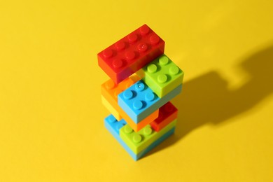 Photo of Construction toy. Figure made with building bricks on yellow background