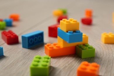 Photo of Construction toy. Colorful building bricks on wooden background, closeup