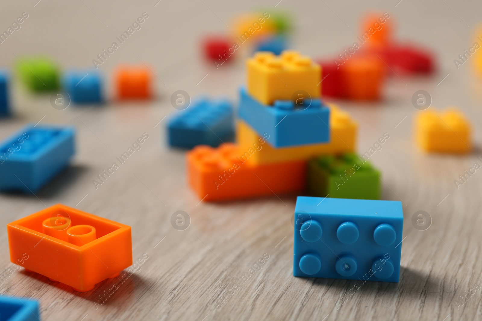 Photo of Construction toy. Colorful building bricks on wooden background, closeup