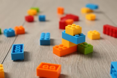 Photo of Construction toy. Colorful building bricks on wooden background, closeup