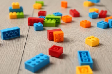 Photo of Construction toy. Colorful building bricks on wooden background, closeup