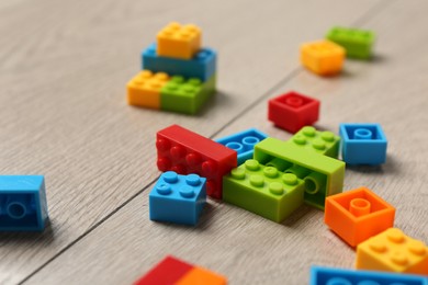 Photo of Construction toy. Colorful building bricks on wooden background, closeup