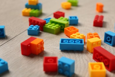 Photo of Construction toy. Colorful building bricks on wooden background, closeup