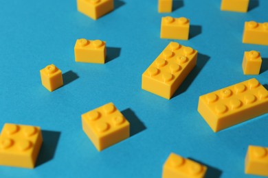 Photo of Construction toy. Colorful building bricks on light blue background, closeup