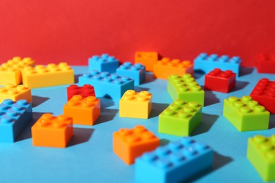 Photo of Construction toy. Colorful building bricks on color background, closeup