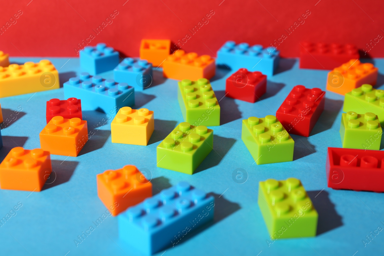 Photo of Construction toy. Colorful building bricks on color background, closeup