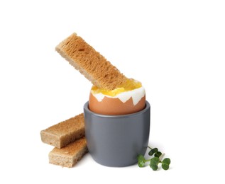 Photo of Soft boiled egg in eggcup with bread isolated on white