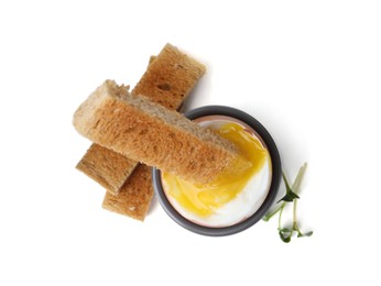 Photo of Soft boiled egg in eggcup with bread isolated on white, top view