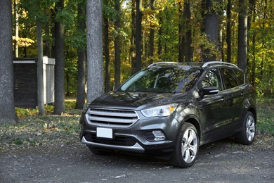 Modern car parked near forest. Autumn season