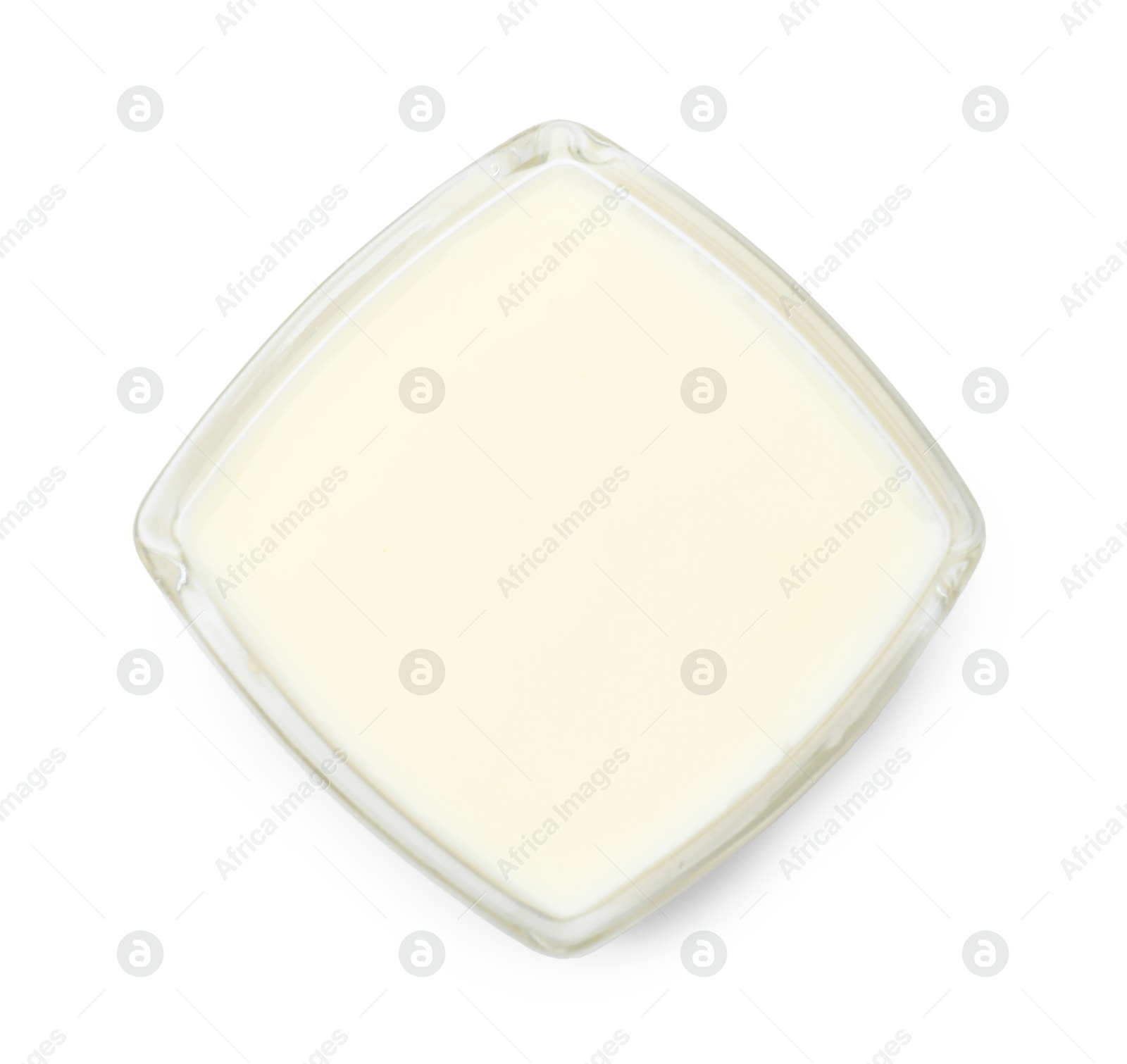 Photo of Condensed milk in bowl isolated on white, top view