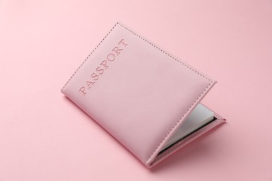 Photo of Passport in color cover on pink background, closeup