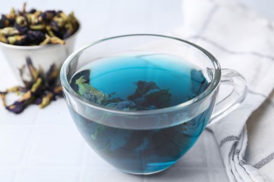 Delicious butterfly pea flower tea on white table, closeup