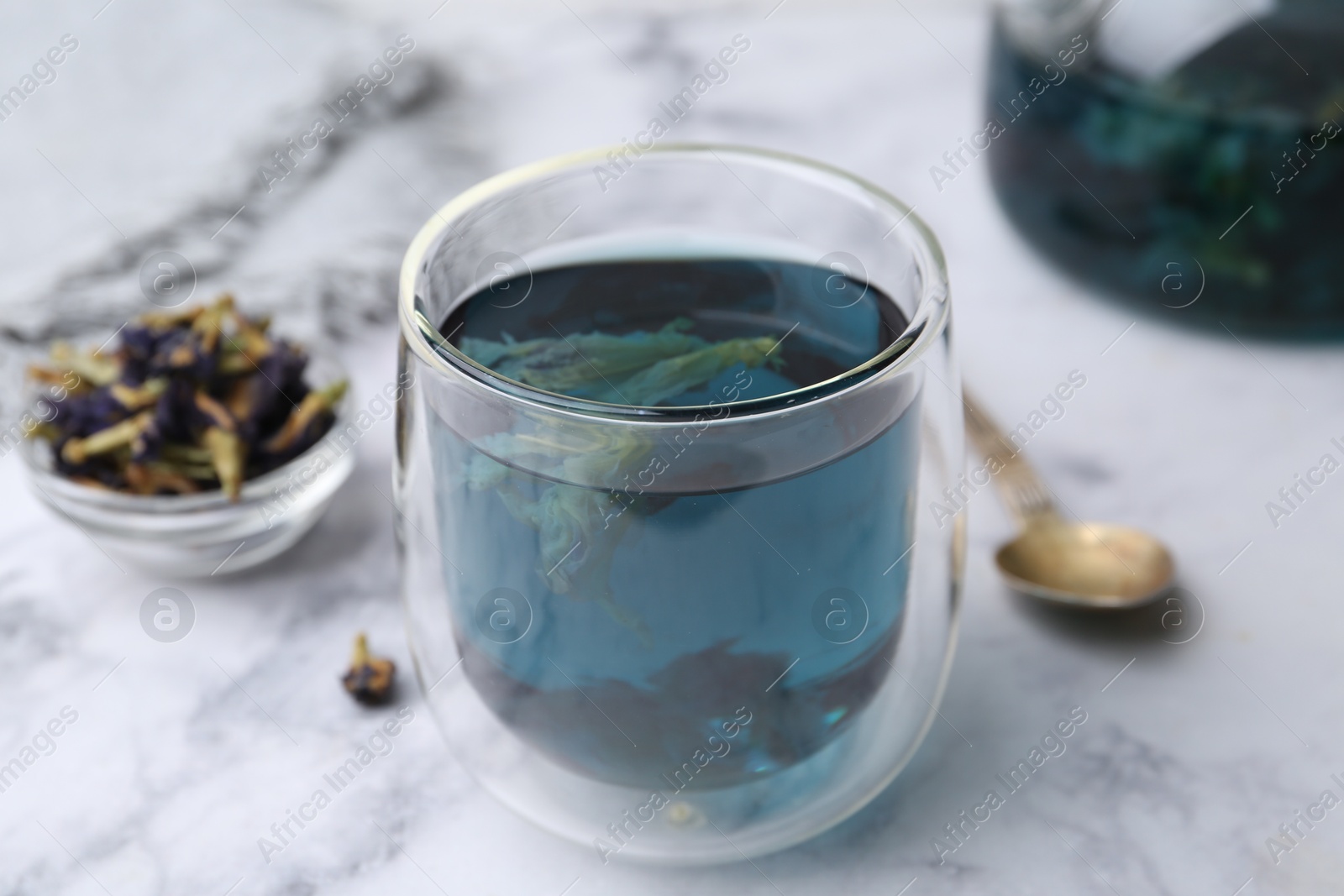 Photo of Delicious butterfly pea flower tea on white marble table, closeup