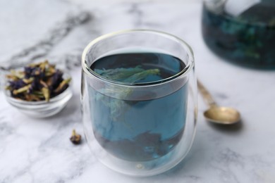 Delicious butterfly pea flower tea on white marble table, closeup