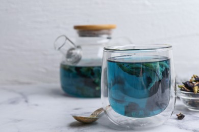 Photo of Delicious butterfly pea flower tea on white marble table. Space for text