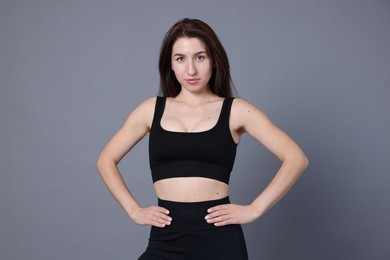 Photo of Portrait of woman in sportswear on grey background