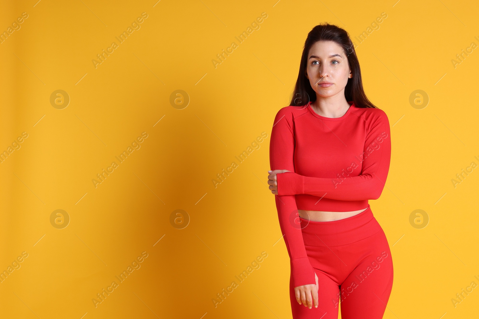 Photo of Portrait of woman in sportswear on orange background, space for text