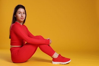 Photo of Portrait of woman in sportswear on orange background, space for text