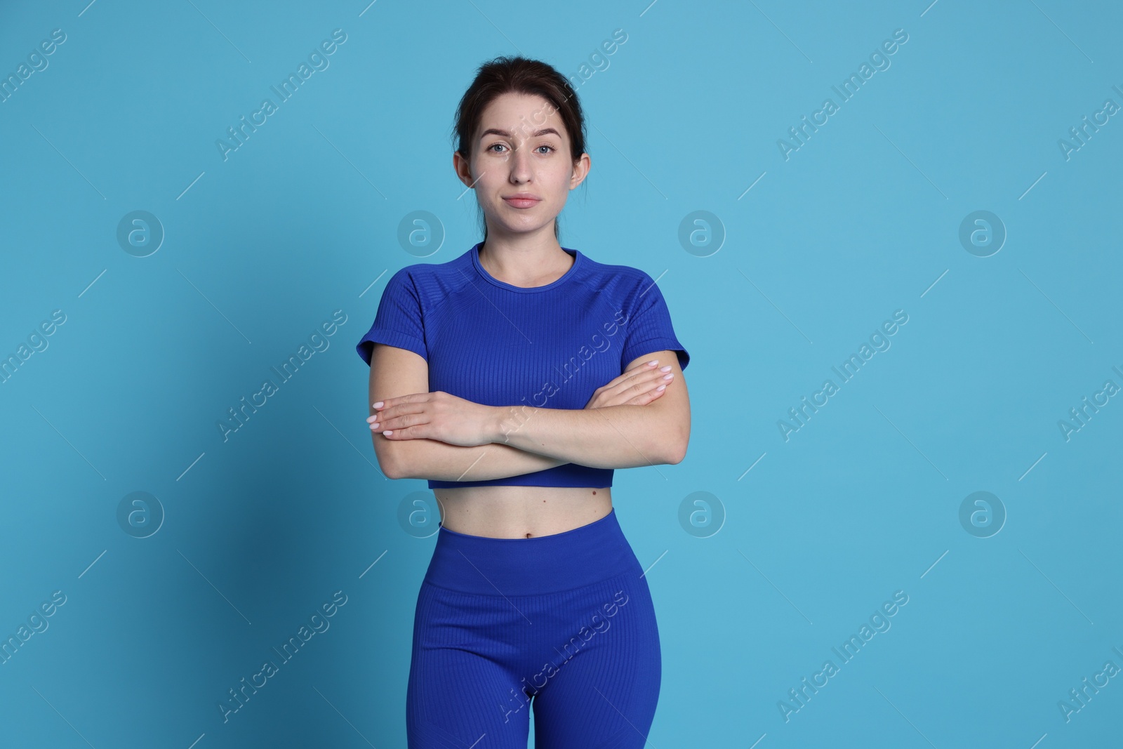 Photo of Portrait of woman in sportswear on light blue background