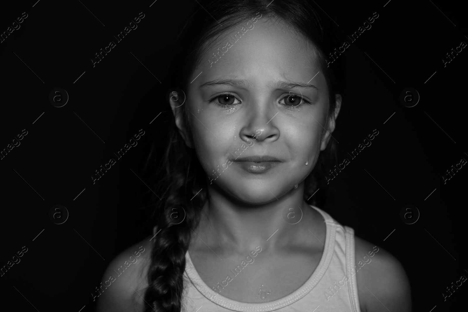 Photo of Orphanage concept. Sad girl on dark background. Black and white effect