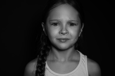 Photo of Orphanage concept. Sad girl on dark background. Black and white effect