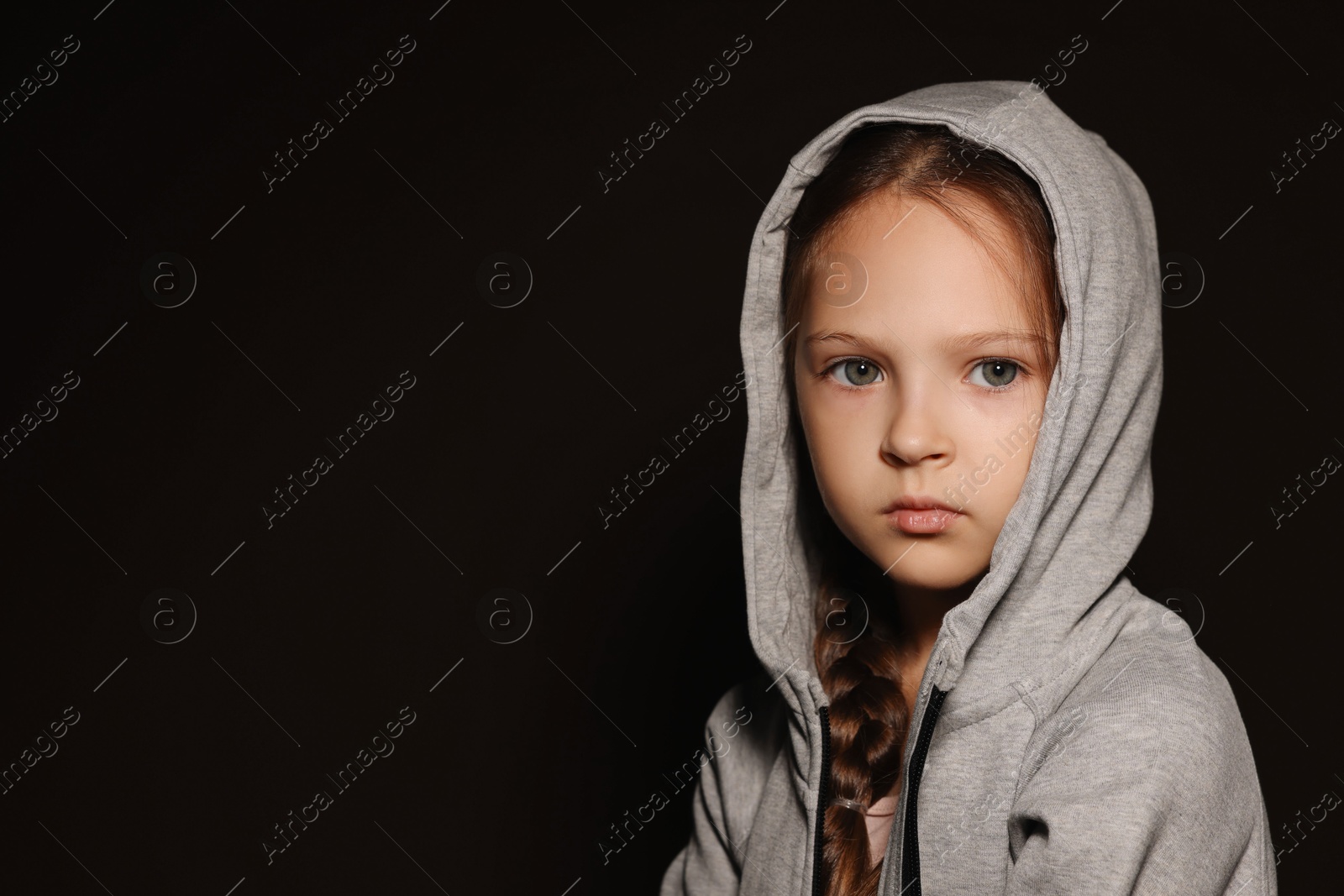 Photo of Orphanage concept. Sad girl on black background, space for text