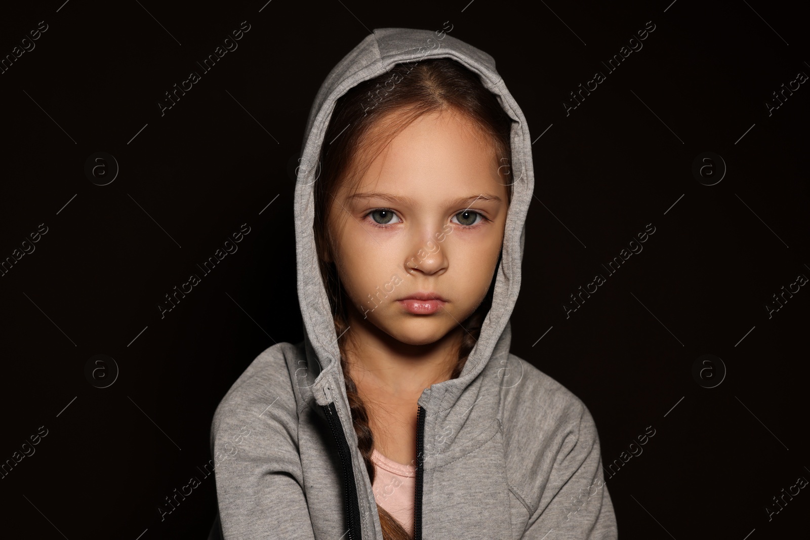 Photo of Orphanage concept. Sad girl on black background