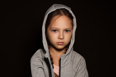 Photo of Orphanage concept. Sad girl on black background