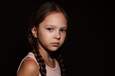 Photo of Orphanage concept. Sad girl on black background