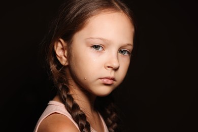 Photo of Orphanage concept. Sad girl on black background