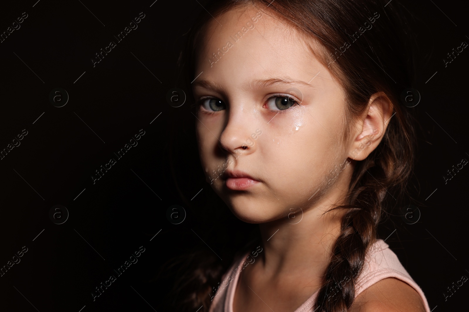 Photo of Orphanage concept. Sad girl on black background