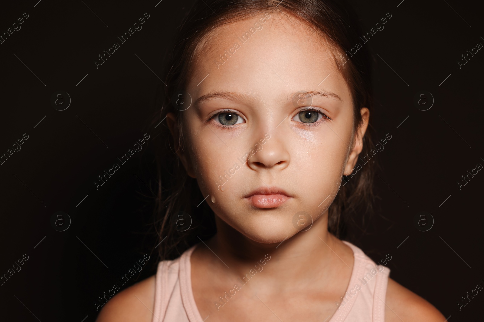 Photo of Orphanage concept. Sad girl on black background