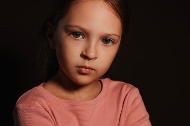 Photo of Orphanage concept. Sad girl on black background