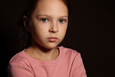 Photo of Orphanage concept. Sad girl on black background