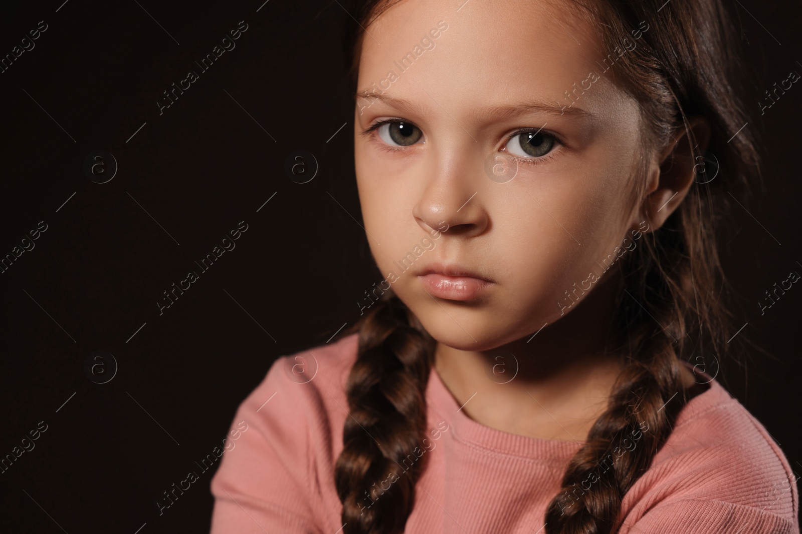 Photo of Orphanage concept. Sad girl on black background