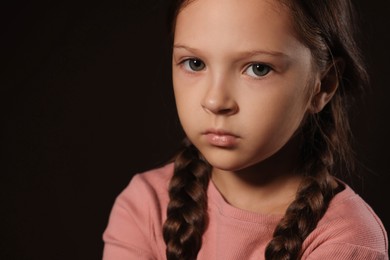 Photo of Orphanage concept. Sad girl on black background