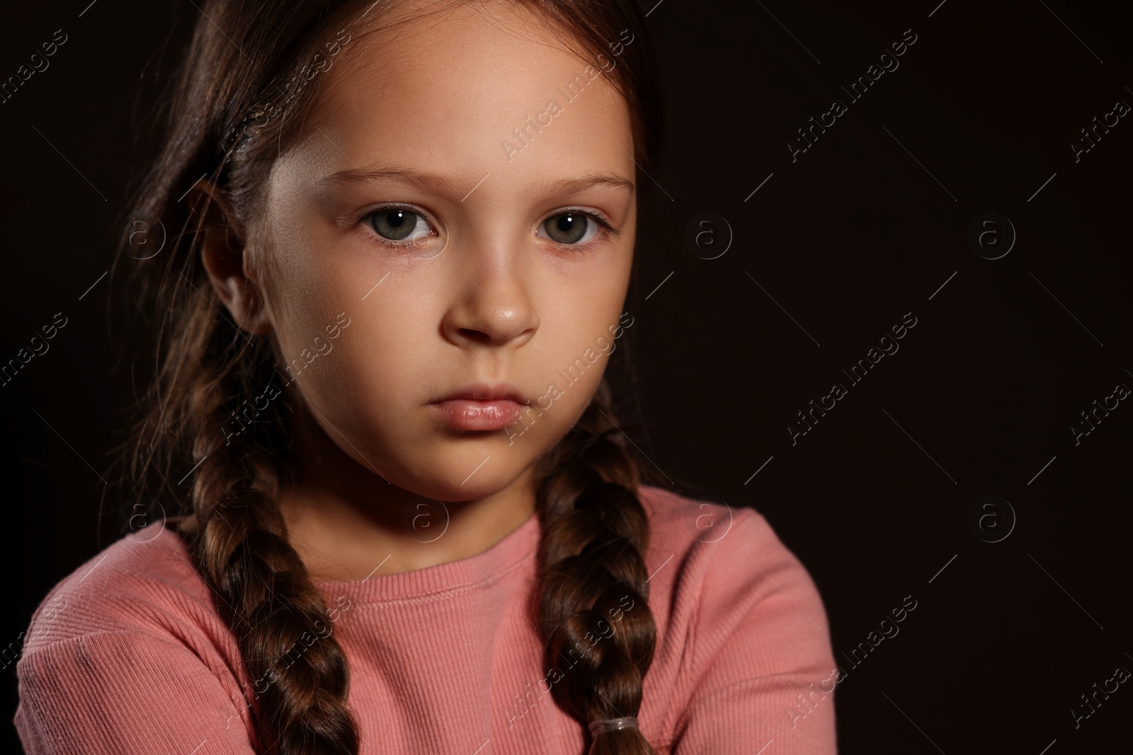 Photo of Orphanage concept. Sad girl on black background