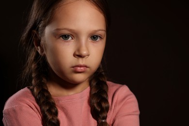 Photo of Orphanage concept. Sad girl on black background